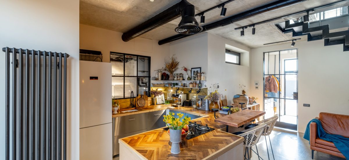 Stylish house living room and kitchen interior in mixed style with the use of natural materials in finishing and furniture. Timeless eclectic style